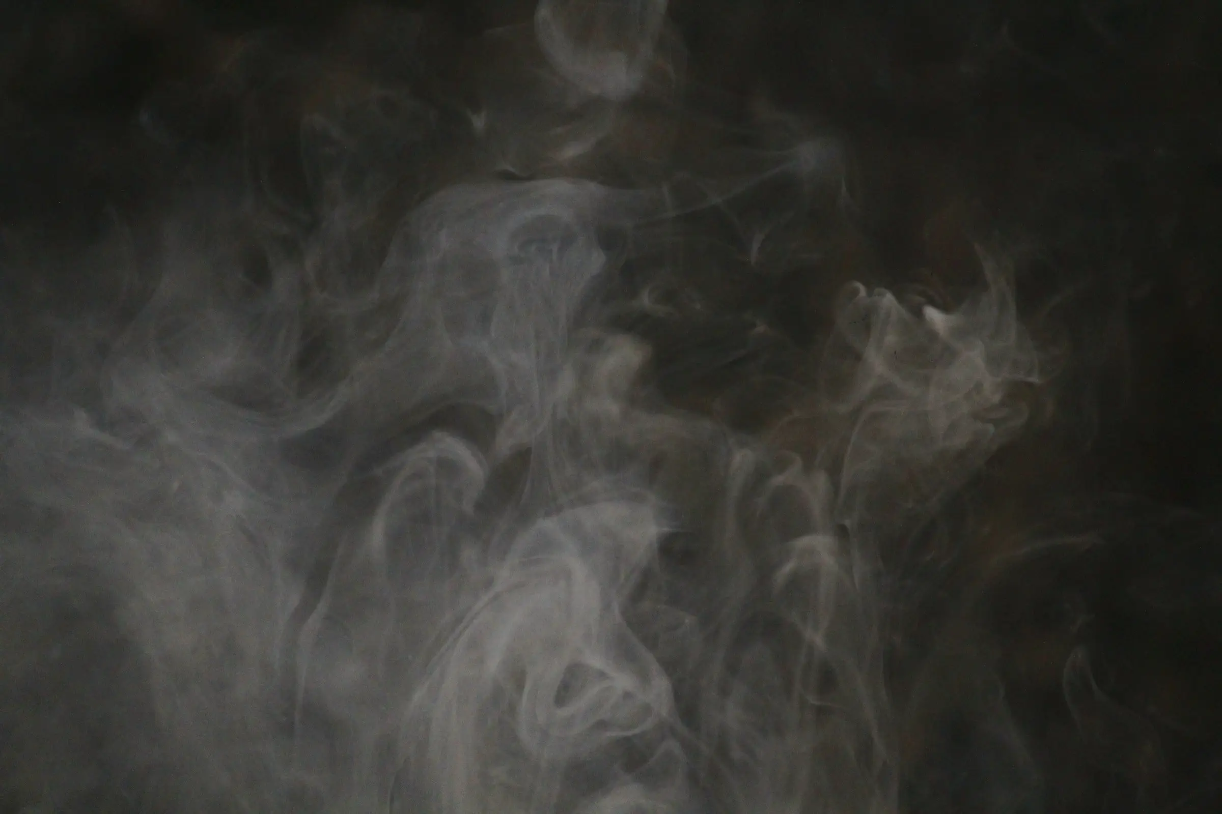 Steam curling against a dark background